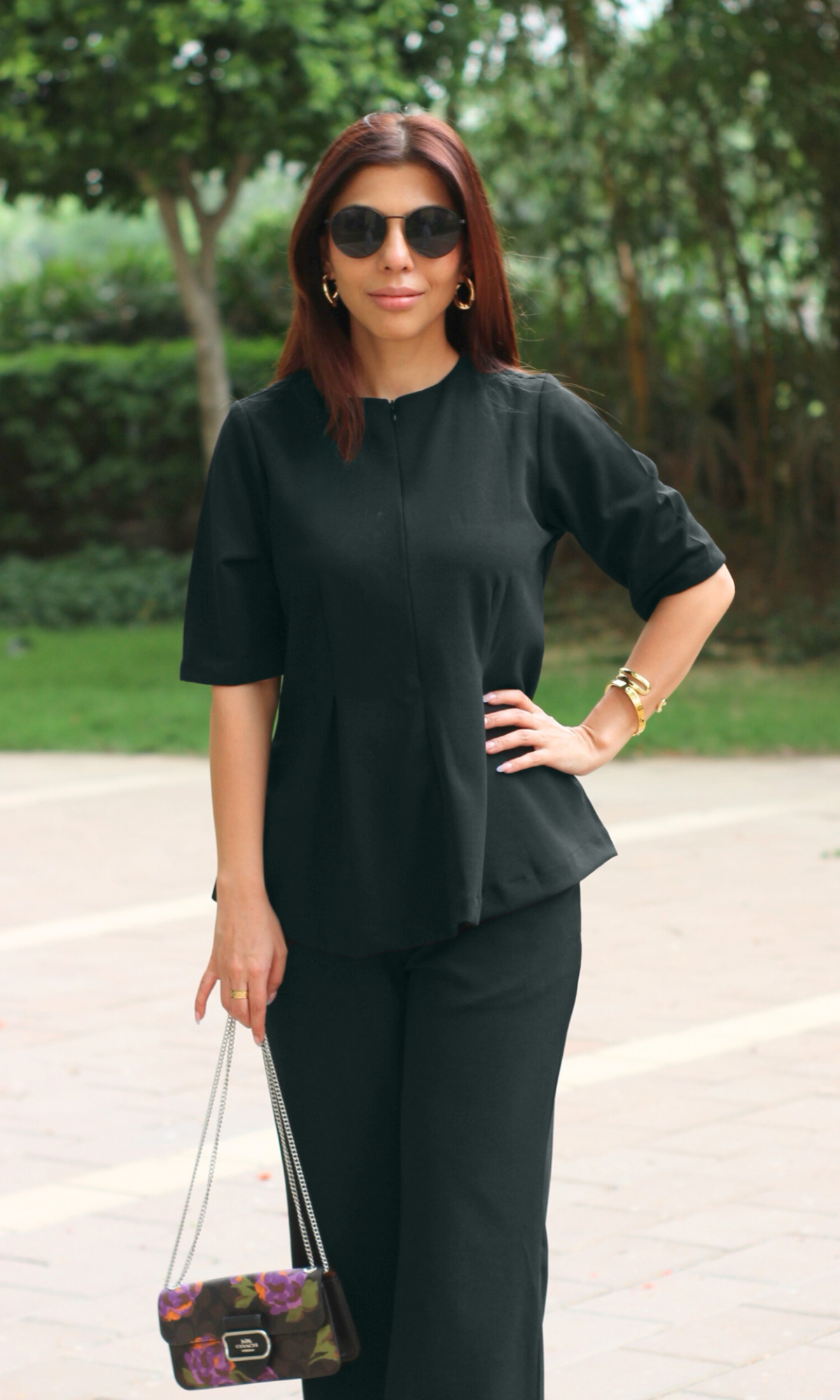 Sophisticated monochrome outfit featuring a black short-sleeve top with peplum detail and tailored wide-leg trousers.