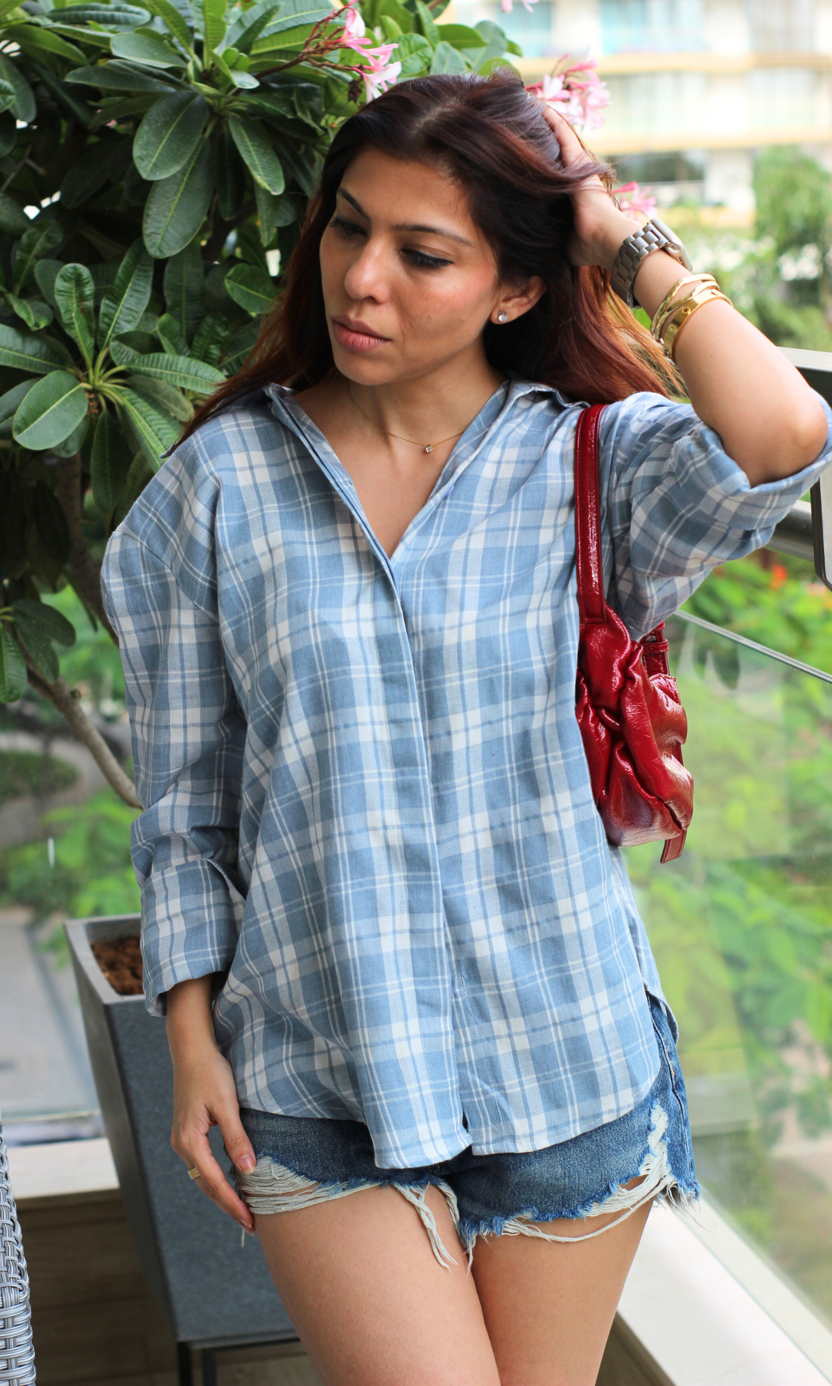 Casual summer look featuring a light blue checkered shirt, ripped denim shorts.