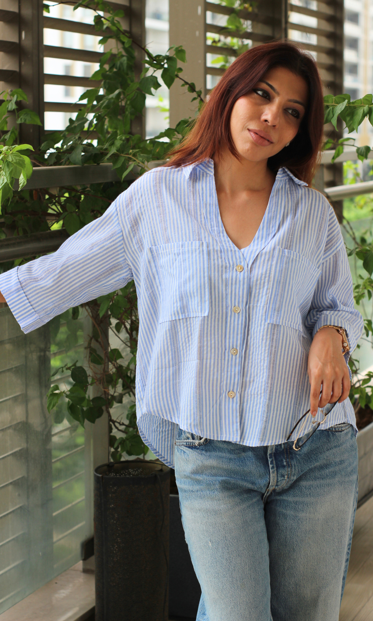 Blue and white striped shirt with front pockets, styled with light-wash jeans.