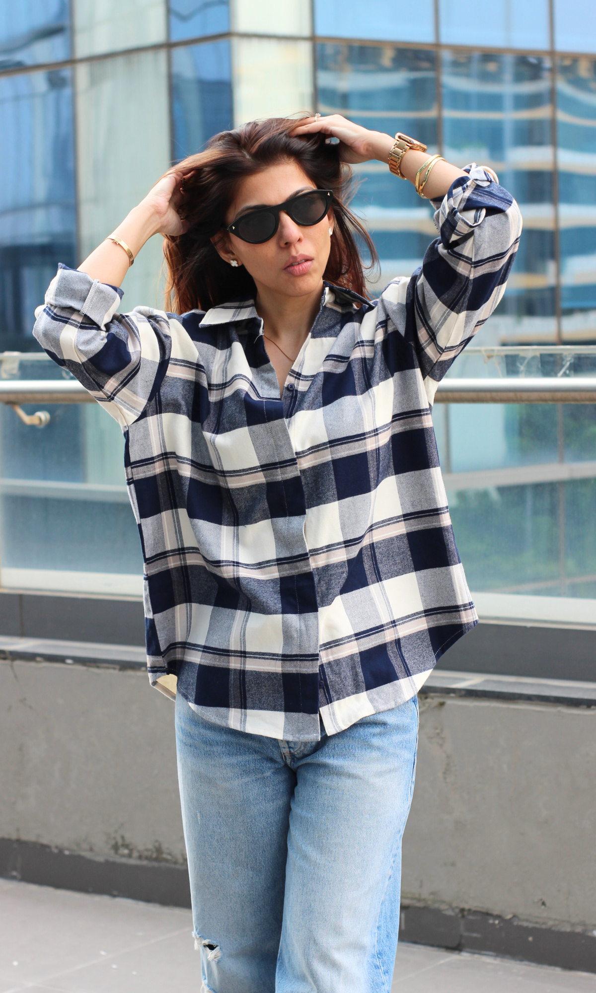 Indigo and ivory checked shirt with a relaxed silhouette, styled open over a white top, perfect for layering on crisp days.
