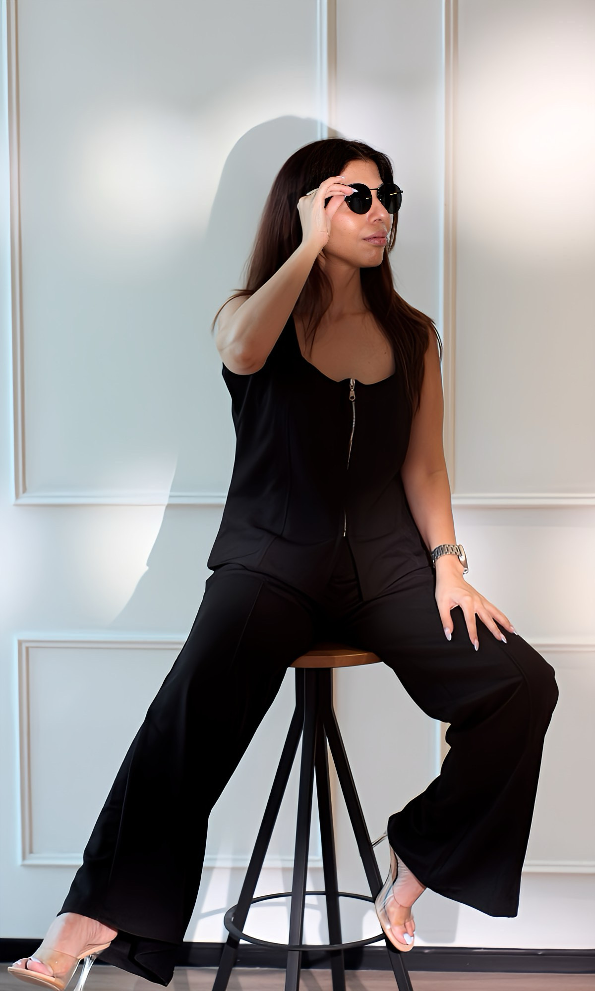 Minimalist black co-ord set with zip-front top and wide-leg trousers, styled with sunglasses and clear heels, perfect for a modern elevated casual look.