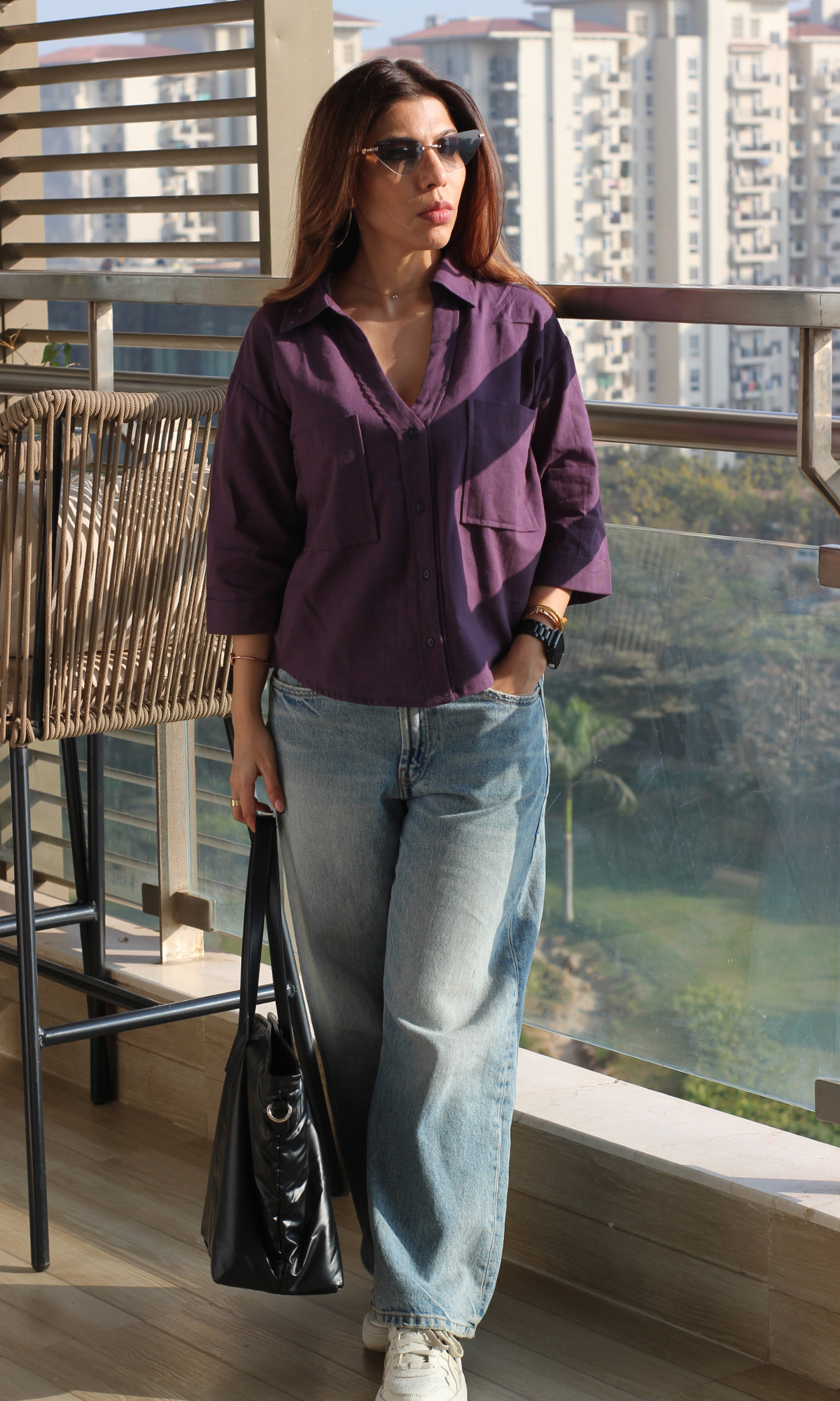 Woman wearing a midnight purple cotton cropped shirt styled with high-waist bottoms
