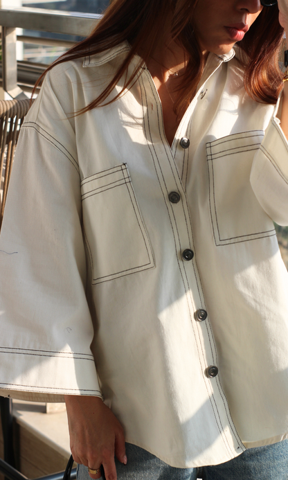 Close-up of white shirt showcasing fine thread embroidery on lightweight fabric