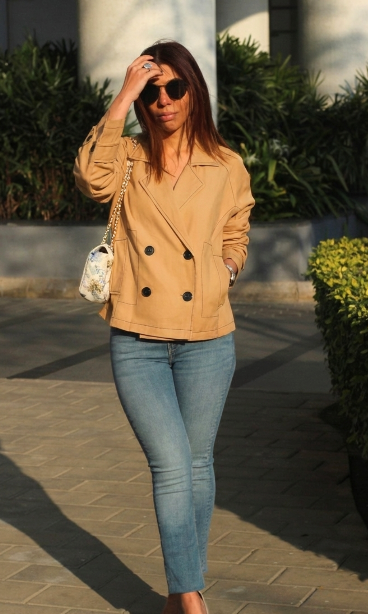 Model wearing tan thread detail trench styled with casual outfit and belt tie waist