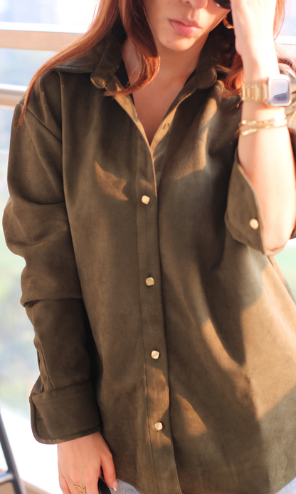 Close-up view of pickle-green suede shirt showing metallic button detailing and smooth textured finish.
