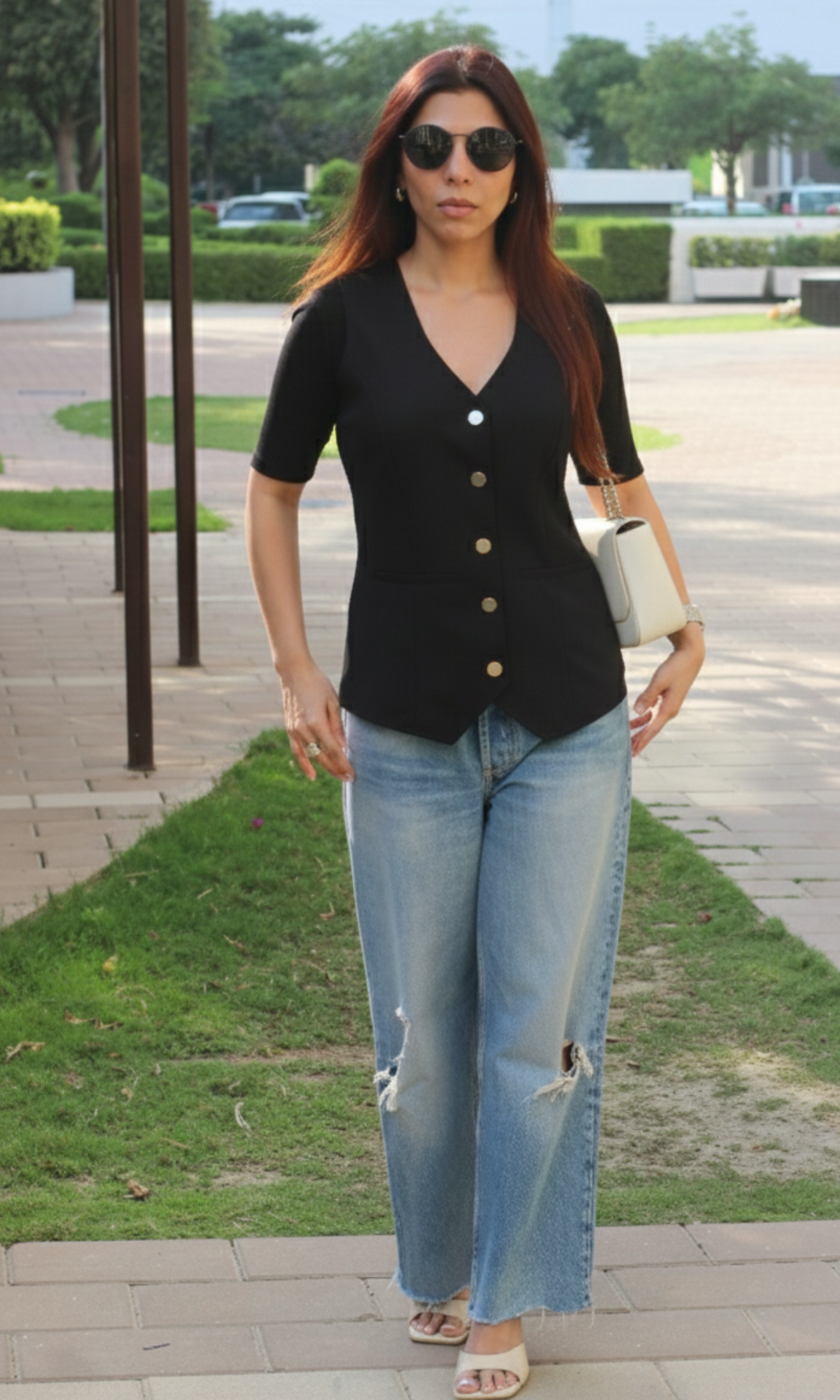 Front view of onyx sleeved waist coat featuring metallic button details and structured silhouette