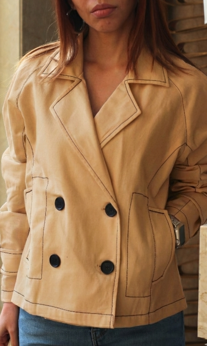 Close-up of tan thread detail trench showing textured fabric and elegant stitching accents