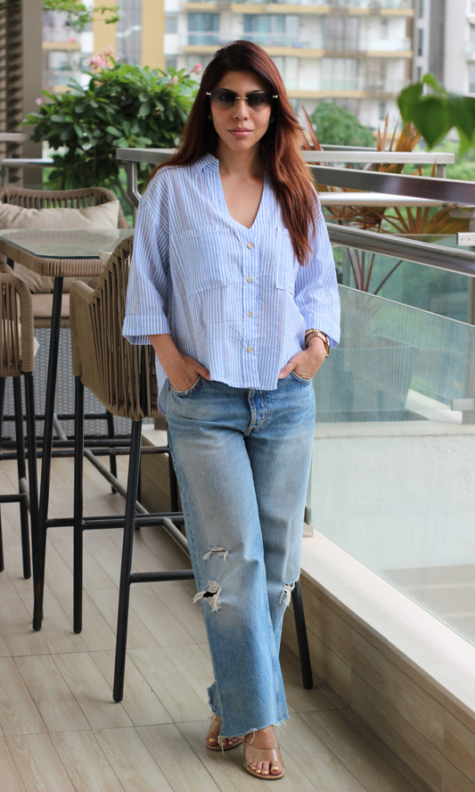 Striped shirt paired with distressed straight-leg jeans and heels.