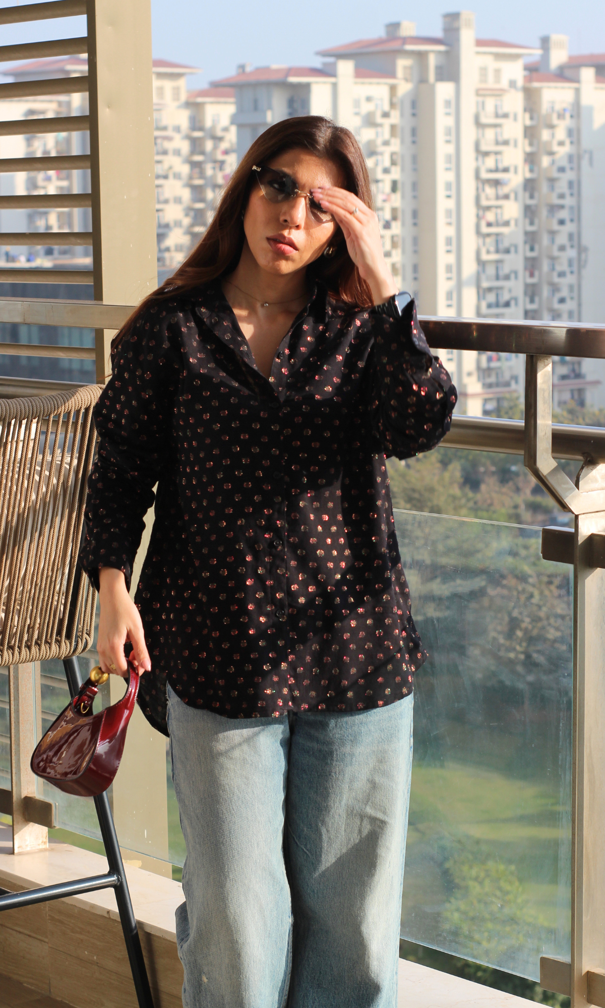 Black lurex flowing shirt displayed on model with relaxed fit and subtle metallic shine.