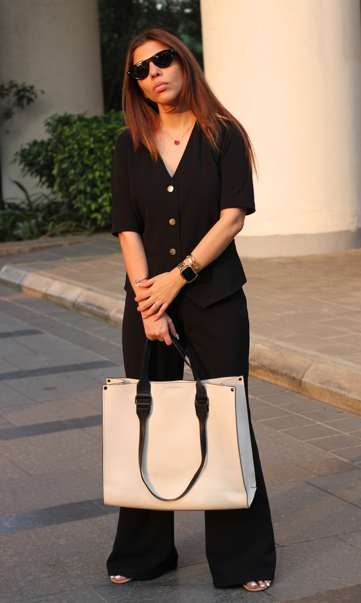 Elegant black sleeved waistcoat paired with high-waisted flared pants