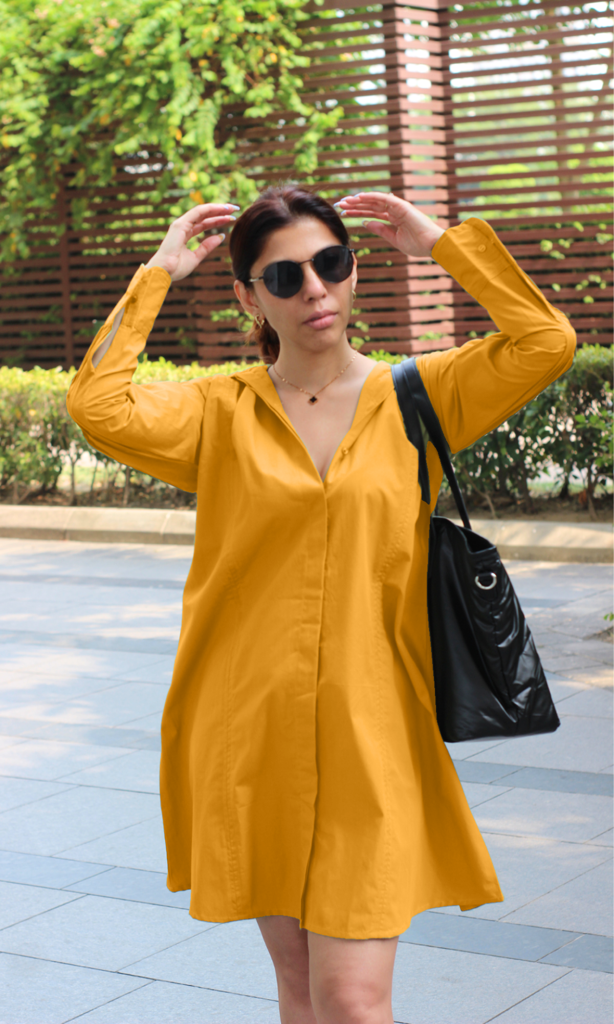Relaxed yet stylish look: long-sleeved mustard yellow shirt dress with a neutral handbag