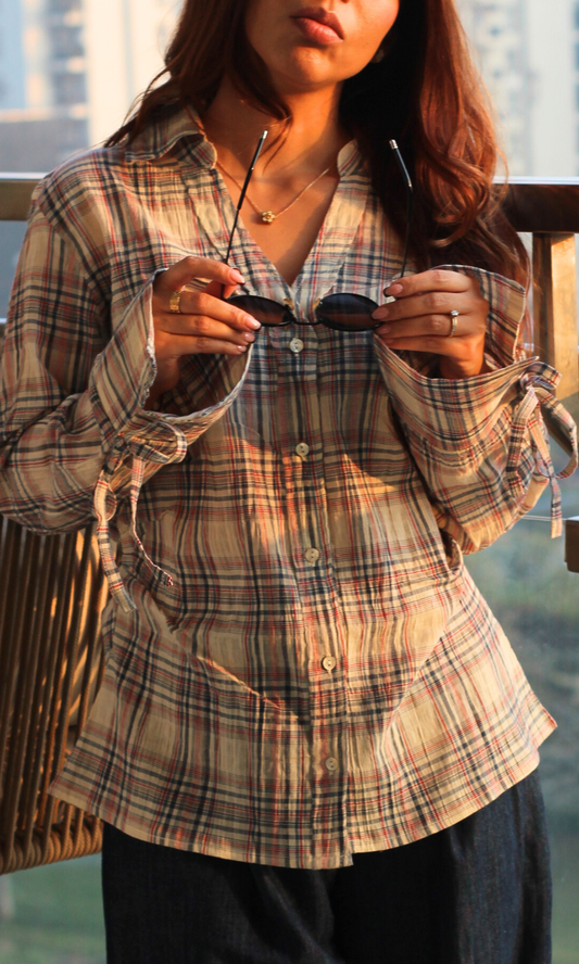 Close-up of blue-blush check cotton fabric with visible string detail on shirt