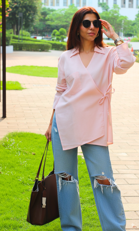 Blush pink linen kimono-style top with cut-detail design and wrap tie, displayed on a mannequin against a bright backdrop.