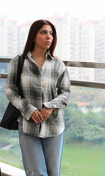 Olive-toned shirt with ivory check pattern, drop shoulders, button-up styling — ideal for wearing over jeans or trousers.