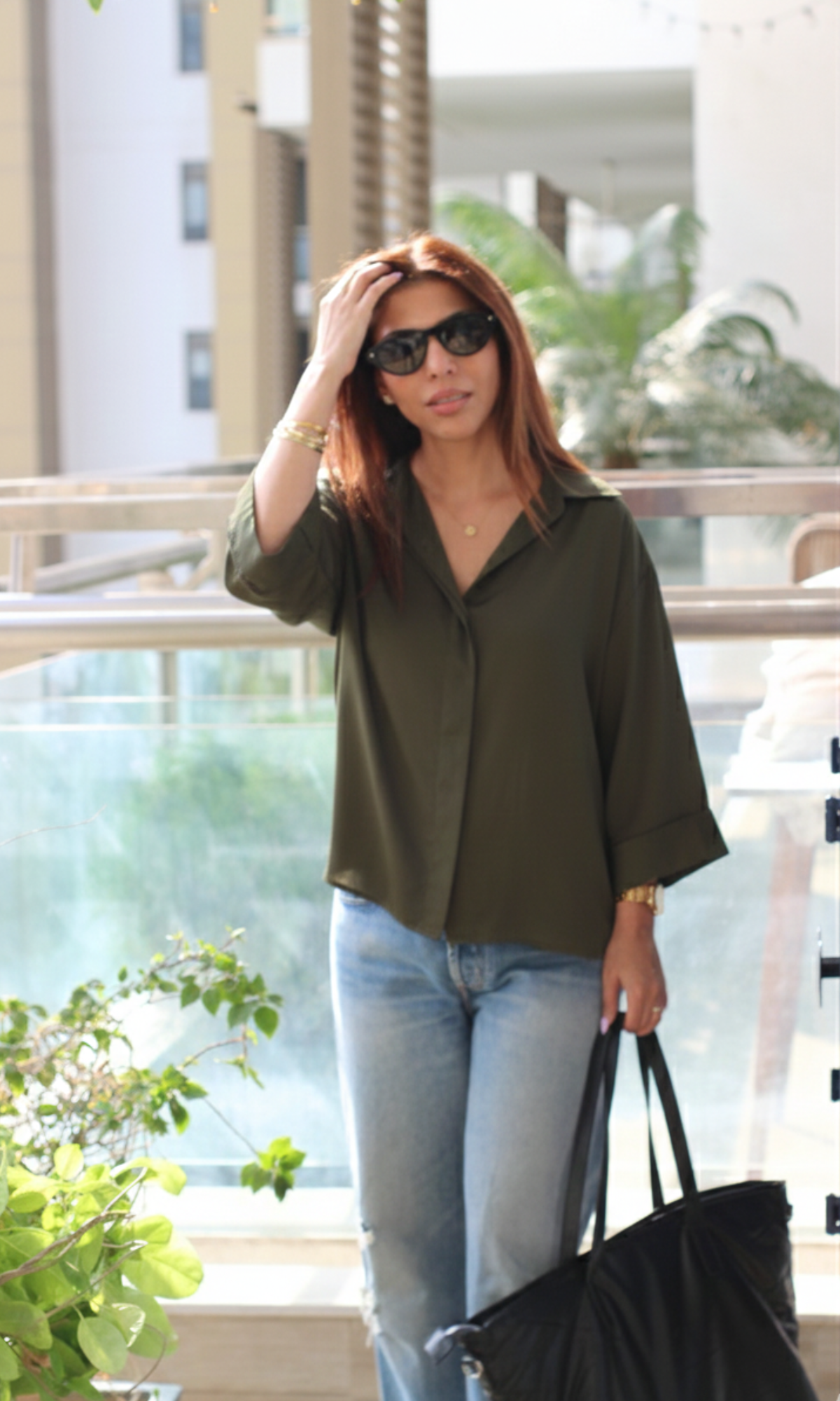 Model wearing olive green sheen loose shirt styled with casual bottoms